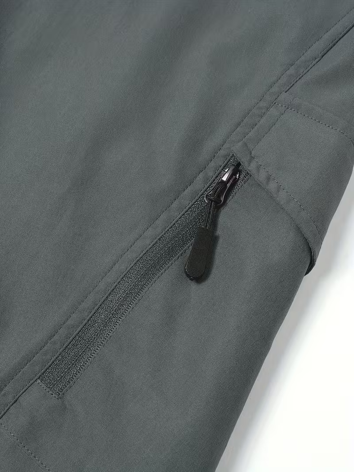 Detalle del bolsillo con cremallera del pantalón gris