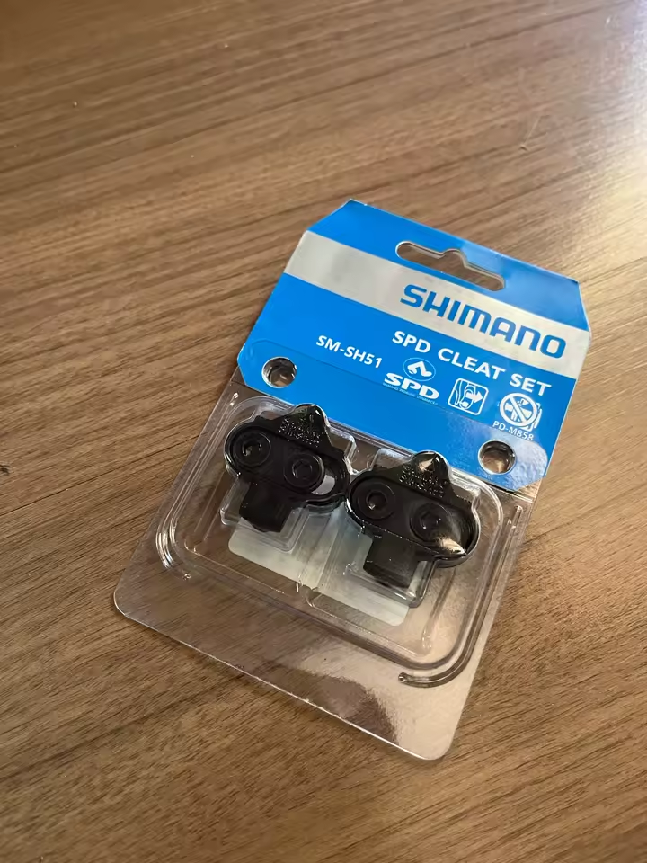Par de calas negras Shimano SM-SH51 en empaque SPD Cleat Set sobre una mesa